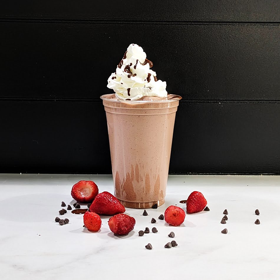 A rich and indulgent shake made with chocolate protein and delicious strawberries, topped with whipped cream and a drizzle of chocolate sauce.